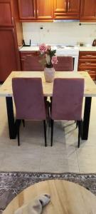 cocina con mesa y 2 sillas moradas en Heaven House, en Sozopoli
