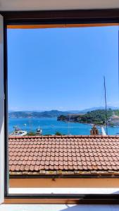 una ventana con vistas al techo y al agua en Bellavista, en Le Grazie