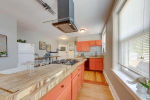a kitchen with orange cabinets and a large window at Inviting St Louis Apartment - Great Location! in Lemay +18 photos