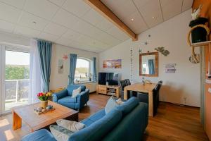 un salon avec des canapés bleus et une télévision dans l'établissement Appartement Celina - Residence Juliana Julianadorp aan Zee, à Julianadorp