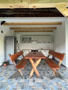 クルツィショアラにあるCASA ANDREIの木製テーブルと椅子2脚付きのキッチン