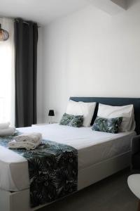 1 dormitorio con 1 cama grande con sábanas y almohadas blancas en StuDio 57 (5), en Néa Khilí