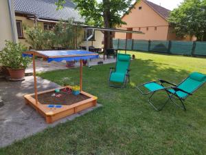 a ping pong table and chairs in a yard at Tartós Szegfű Vendégház, Magánszállás in Tázlár