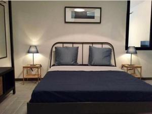 ナポリにあるStyle And Roomのベッドルーム1室(青いシーツとランプ2つ付)