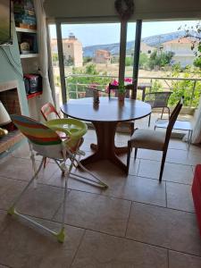 a table and chairs in a room with a balcony at Sunset at Cape Sounio in Sounio