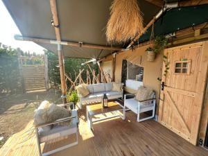 - une terrasse couverte avec un canapé et des chaises dans l'établissement LA PEÑA LUXURY(TARIFA), à Tarifa