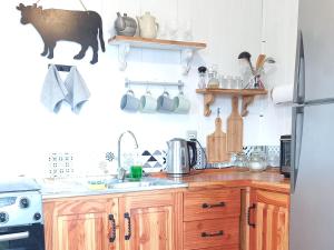 - une cuisine avec des placards en bois et un réfrigérateur dans l'établissement Cabaña Lourdes, à Puerto Corral