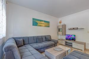 a living room with a blue couch and a tv at Mara in Umag