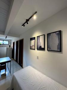 1 dormitorio con 1 cama y 4 cuadros en la pared en Pituba Ville - Ap - 1 andar - 2/4, en Itacaré