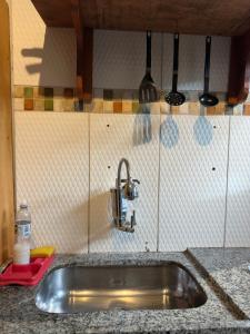 un lavandino in acciaio inossidabile in una cucina con utensili di Pituba Ville - Ap - 1 andar - 2/4 a Itacaré