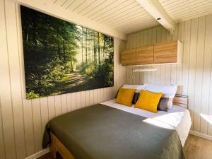 a bed in a small room with a painting on the wall at Charme à Graide in Graide +19 photos