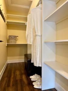 a walk in closet with white shelves and wood floors at Lotus Moon in Charlottetown