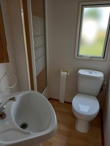 ムロンゴヴォにあるDomki i pokoje nad stawem koło Mrągowaのバスルーム(トイレ、洗面台付)、窓が備わります。