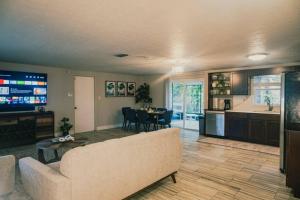 sala de estar con sofá, mesa y cocina en The Lake House (Tampa / LUTZ area) en Lutz