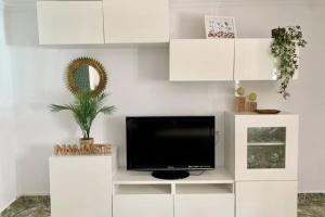 a living room with a tv and white cabinets at La Casa de los Tiles in Vélez Blanco