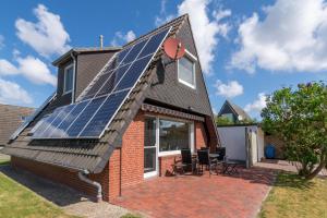 uma casa com painéis solares no telhado em Spatzenhorst em Dornumersiel