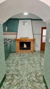 a kitchen with green cabinets and a fireplace at La Casa de los Tiles in Vélez Blanco