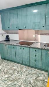 a kitchen with green cabinets and a sink at La Casa de los Tiles in Vélez Blanco +12 photos