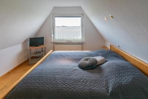 um quarto com uma cama grande e uma janela em Spatzenhorst em Dornumersiel