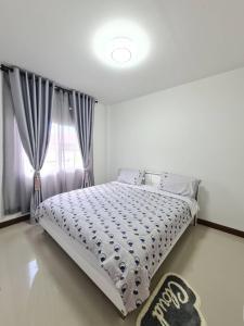 a white bed in a bedroom with a window at เอกกวินอุ่นรัก in Ban Kut Kwang