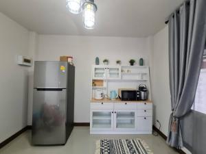 a kitchen with a stainless steel refrigerator and a counter at เอกกวินอุ่นรัก in Ban Kut Kwang