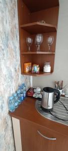 um balcão de cozinha com uma chaleira de chá e copos de vinho em Villa Central Riverside em Mostar