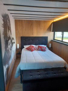 una camera con un letto con due cuscini sopra di Leonchic - Guest House com Piscina de Água Salgada a Barcelos