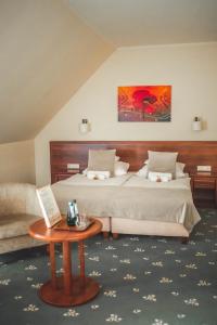 a bedroom with a large bed and a table at Hotel Rycerski in Czeladź