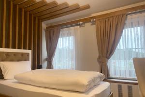 a bedroom with a bed with a large window at Spreehotel Spremberg in Spremberg