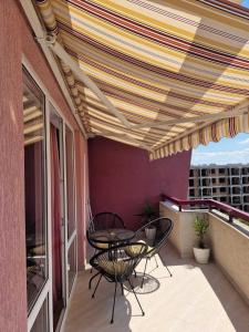 a patio with a table and chairs on a balcony at Cabana Beach Club Complex in Nesebar