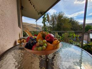 un cesto di frutta seduto su un tavolo di vetro di Guesthouse Mtkvari a Nak'alak'evi