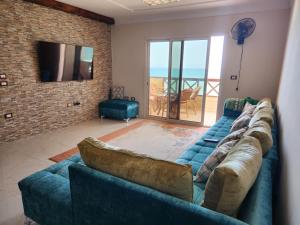 a living room with a blue couch and a television at شقة مصيف الاسكندرية - البيطاش بيانكي in Alexandria