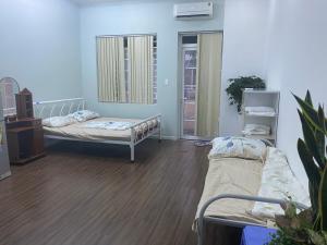 een ziekenhuiskamer met twee bedden en een spiegel bij Vina Home in Ho Chi Minh-stad +28 foto's