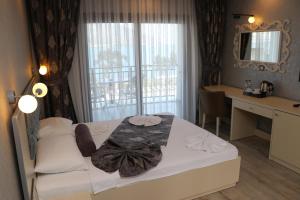 TOROS DELUXE RESORT HOTEL في يسيلوفاجيك: غرفة نوم بسرير ومكتب ونافذة