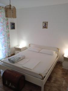 a white bed in a bedroom with two lamps at Villa Eminenza in Cersuta di Maratea