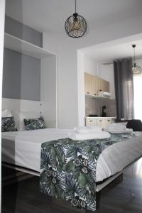 una camera bianca con un grande letto con una coperta verde di StuDio 57(10) a Néa Khilí