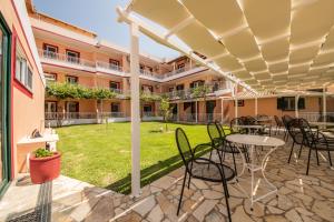 a patio with a table and chairs under a pergola at Kalias Hotel in Vasiliki