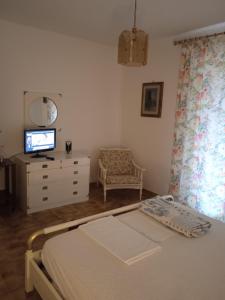 a bedroom with a bed and a tv and a dresser at Villa Eminenza in Cersuta di Maratea