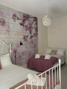 1 dormitorio con 2 camas y un mural de flores en Seaside pearl, en Ligia