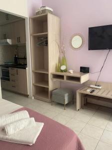 a living room with a table and a tv and a kitchen at Seaside pearl in Lygia