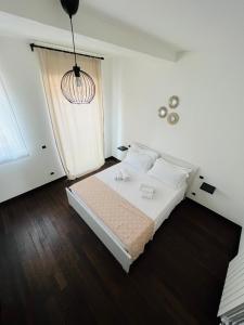 a white bedroom with a bed and a window at Settembre in Sannicandro di Bari