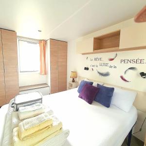 ein Schlafzimmer mit einem weißen Bett und Handtüchern darauf in der Unterkunft Mer et Liberté in Saint-Brevin-les-Pins