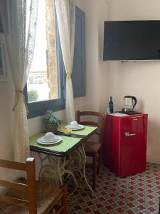 una cucina con tavolo e frigorifero rosso di B&B Visìta_experience a Torre Santa Susanna