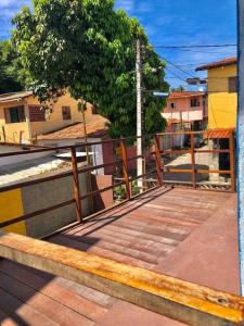 a wooden deck with a fence and a tree at Flat Mirante in Pipa