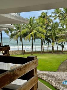 vistas a una playa con palmeras y al océano en Jatiuca Suítes Resort FLAT en Maceió