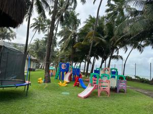 a playground with colorful play equipment on the grass at Jatiuca Suítes Resort FLAT in Maceió