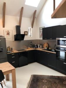 a kitchen with black cabinets and black appliances at Gîte de Coussane 2 in Espalion