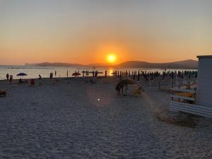a group of people on a beach at sunset at A 300 m dal mare: signorile e silenzioso in Alghero