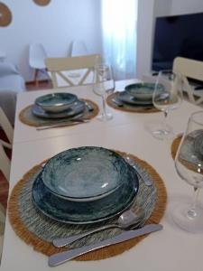 einen Tisch mit drei Tellern und Weingläsern darauf in der Unterkunft Casa, 300 metros Playa, Wifi, Parking. in Vera