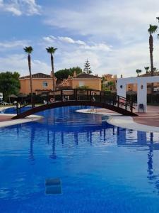 eine Brücke über einen großen Pool mit blauem Wasser in der Unterkunft Casa, 300 metros Playa, Wifi, Parking. in Vera